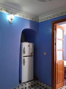 a refrigerator in a room with a blue wall at Casa Lotfi 1 in Chefchaouene