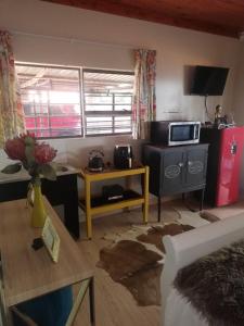 a living room with a couch and a table with a microwave at Shai's Studio in Centurion
