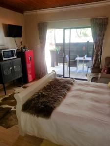 a bedroom with a large bed with a fur rug on it at Shai's Studio in Centurion