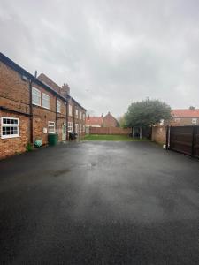 an empty parking lot next to some brick buildings at Maypole Farm, Cawood in Selby