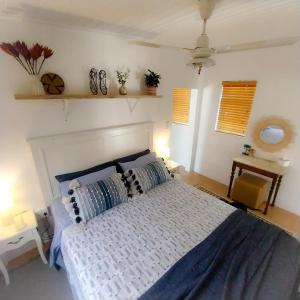 a bedroom with a large bed with blue and white sheets at The Little Gem in Montagu