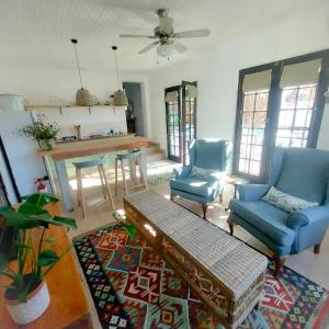 a living room with two blue chairs and a table at The Little Gem in Montagu