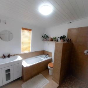 a bathroom with a tub and a toilet and a sink at The Little Gem in Montagu