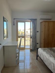 Un dormitorio con una cama y un escritorio y una ventana. en Villa Touristic Village Nr 7030, en Hurghada 20 fotos más