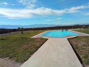 une piscine au milieu d'un champ dans l'établissement Family villa with swimming pool and a wonderful mountain view, à Marrakech