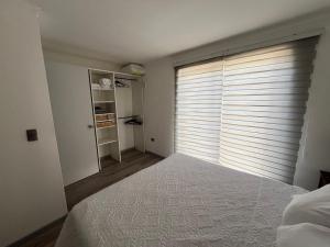 - une chambre avec un lit et une grande fenêtre dans l'établissement Casa en Villa Galilea, à Curicó