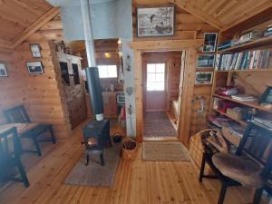 a living room with a stove in a log cabin at Lakeside Holiday Cottage near Ivalo - Minna-Carita's in Ivalo