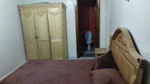 Zenika immobilier في مكناس: غرفة نوم مع سرير وخزانة في غرفة