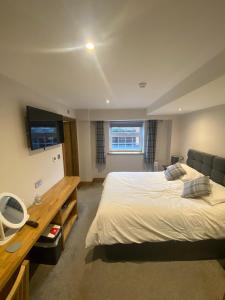 a bedroom with a bed and a desk and a television at Maypole Farm, Cawood in Selby