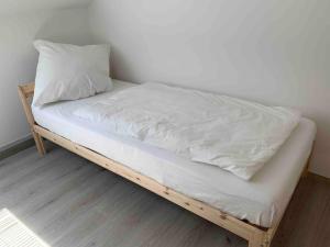łóżko z białą pościelą i poduszką w obiekcie Ferienapartment Allgäu-Idyll (Dietmannsried) w mieście Dietmannsried