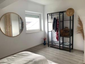 a white room with a mirror and a bed at Ferienapartment Allgäu-Idyll (Dietmannsried) in Dietmannsried