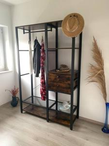 un estante de libros negros con un sombrero encima en Ferienapartment Allgäu-Idyll (Dietmannsried) en Dietmannsried