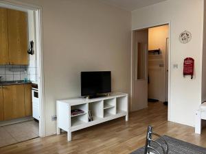 a living room with a tv on a white cabinet at Kuninkaankatu Apartment - Free Parking in Kuopio