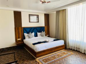 a bedroom with a large bed with a blue headboard at HOTEL MAA LAXMI PALACE in Deoghar