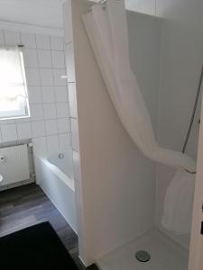 uma casa de banho branca com uma banheira e um lavatório em Ferienwohnung Bergblick em Winterberg