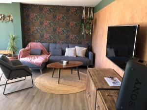 sala de estar con sofá y mesa en Adorable Appartement de 60 m2 avec terrasse privée de 100m2 -lumineux - calme et verdure à 10 min de la mer, en Cagnes-sur-Mer