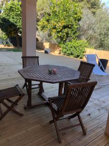 una mesa de madera y 2 sillas en una terraza en Adorable Appartement de 60 m2 avec terrasse privée de 100m2 -lumineux - calme et verdure à 10 min de la mer, en Cagnes-sur-Mer