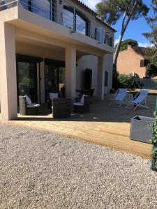 un patio con sillas y una casa en Adorable Appartement de 60 m2 avec terrasse privée de 100m2 -lumineux - calme et verdure à 10 min de la mer, en Cagnes-sur-Mer