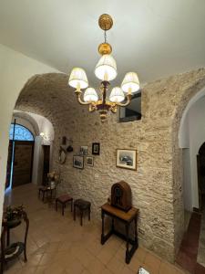a large room with a stone wall and a chandelier at Le Prigioni del Palazzo B&B in Sora