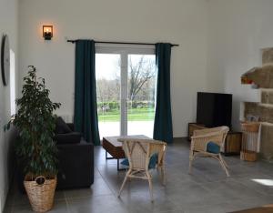 Gîte de charme à la ferme - 6 personnes في Landrévarzec: غرفة معيشة مع أريكة وطاولة وكراسي
