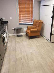 ein Wohnzimmer mit einem Stuhl und einem Tisch in der Unterkunft Heart of City DE1 Studio Apartment in Derby