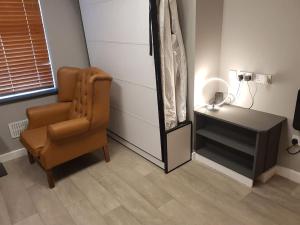 Zimmer mit Stuhl, Kommode und Spiegel in der Unterkunft Heart of City DE1 Studio Apartment in Derby