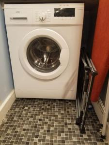 a washing machine in a room with a tile floor at Heart of City DE1 Studio Apartment in Derby