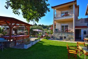 an outdoor patio with tables and chairs and a building at Nikiti Spathies Resort - Double Bedroom Sofita in Kalogria