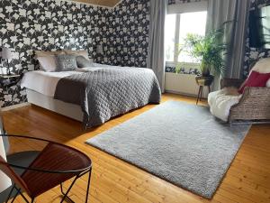 a bedroom with a bed and a chair and a rug at BySannah in Porvoo