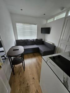 a living room with a couch and a table at Nice and Cosy One Bed Flat in Carshalton