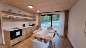 a kitchen and dining room with a wooden table and chairs at Chalets Hrabovo in Ružomberok