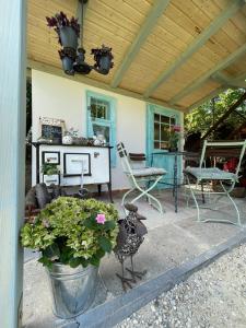 a porch with a chair and a table and a bench at Platán Apartmanház in Balatongyörök