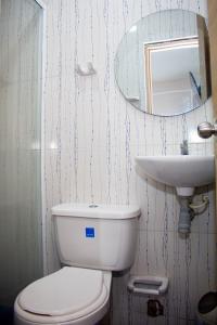 La salle de bains est pourvue de toilettes blanches et d'un lavabo. dans l'établissement Hotel Horizon In, à Santa Marta