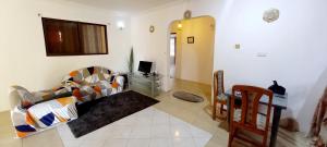 ein Wohnzimmer mit einem Sofa und einem TV in der Unterkunft Cozy 2 Bedroom Peduase Valley Resort View Apartment in Peduasi