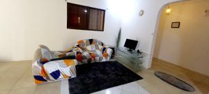 sala de estar con sofá y TV en Cozy 2 Bedroom Peduase Valley Resort View Apartment, en Peduasi