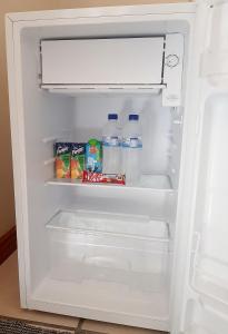 an open refrigerator with milk and water in it at Stay on Lane in Swellendam