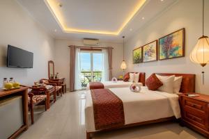 Habitación de hotel con cama y TV en Iris De Villa Hoi An, en Hoi An