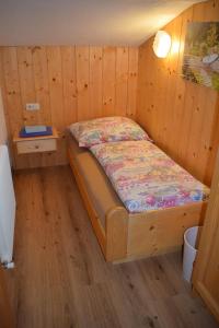 een slaapkamer met een bed in een houten kamer bij Apart Gertrud in Kappl
