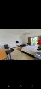 a bedroom with a bed and a desk and a tv at Tam Studio in La Gaulette