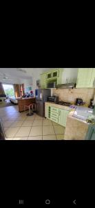 a kitchen with green cabinets and a kitchen with a table at Tam Studio in La Gaulette