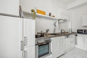 a white kitchen with white cabinets and appliances at Zentrale Lage ... Ideal für Geschäftsleute, Monteure, Familien...3 Zimmer, Wlan, SmartTV in Mettmann