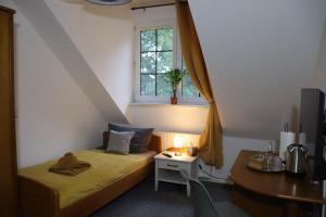 Kleines Zimmer mit einem Bett, einem Schreibtisch und einem Fenster in der Unterkunft Pension Lausitzer Seenland in Elsterheide