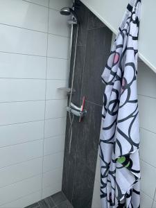 a shower with a shower curtain in a bathroom at Havs nära in Falkenberg