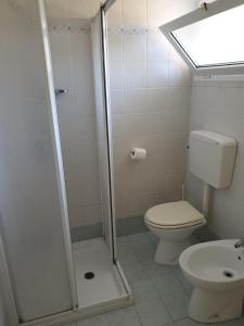 a small bathroom with a toilet and a shower at Residence natura beach in Lido di Volano