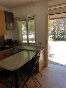 a kitchen with a table and chairs and a window at Residence natura beach in Lido di Volano