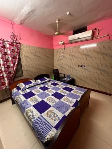 a bedroom with a bed with a blue and white quilt at Sri Thirumal Home Stay in Kumbakonam