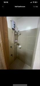 een badkamer met een douche en een zeepdispenser bij South Residences in Manilla