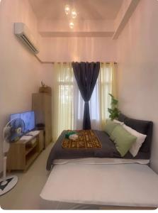 a bedroom with a large bed and a window at South Residences in Manila