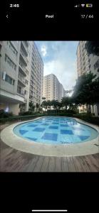a large blue swimming pool in front of some buildings at South Residences in Manila