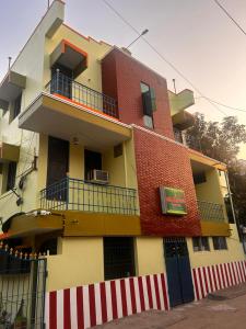 a yellow and red building with a balcony at Sri Thirumal Home Stay in Kumbakonam